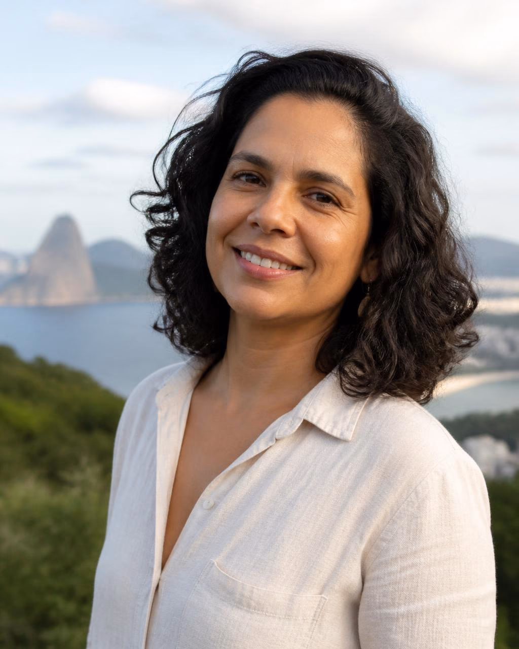 Retrato de uma apresentadora fictícia sorrindo ao ar livre, com paisagem desfocada ao fundo.